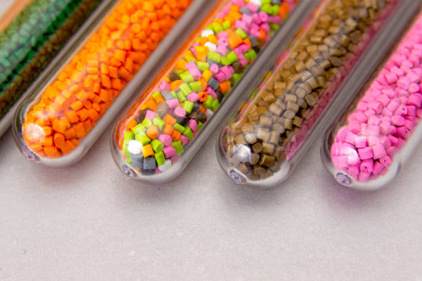 Plastic pellets .Polymeric dye in test tubes on gray background. Plastic granules after processing of waste polyethylene and polypropylene.Polymer.